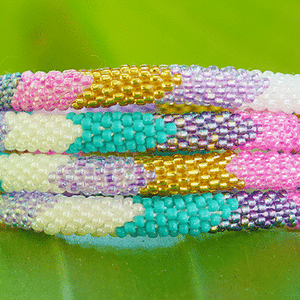 Sashka Co handmade beaded friendship bracelet with turquoise, gold, pink, purple, and white glass beads. Crafted in Nepal by skilled artisans.
