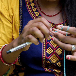 Sashka Co handmade beaded friendship bracelet with turquoise, white, bronze, and blue glass beads. Crafted in Nepal by skilled artisans in an arrow pattern.
