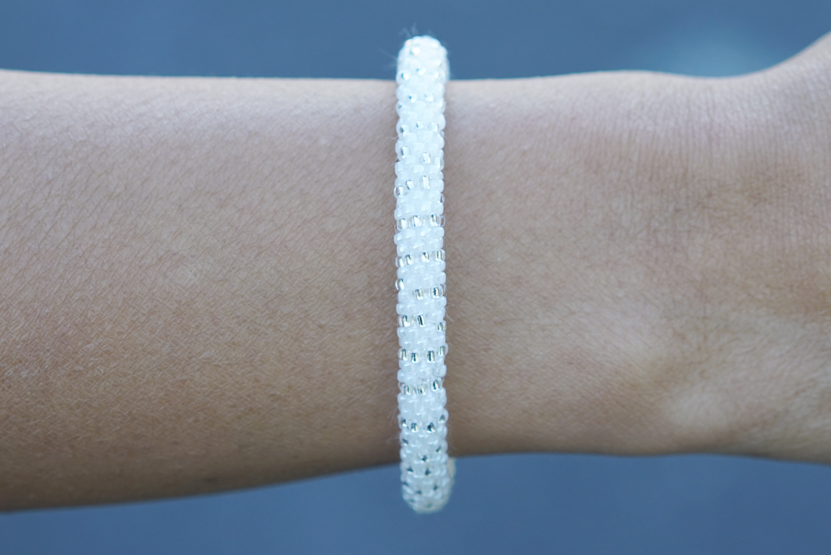Sashka Co handmade beaded friendship bracelet with white and clear glass beads. Crafted in Nepal by skilled artisans in a detailed line pattern.