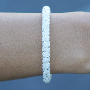 Sashka Co handmade beaded friendship bracelet with white and clear glass beads. Crafted in Nepal by skilled artisans in a detailed line pattern.