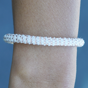 Sashka Co handmade beaded friendship bracelet with white and rose gold glass beads. Crafted in Nepal by skilled artisans in a line pattern.