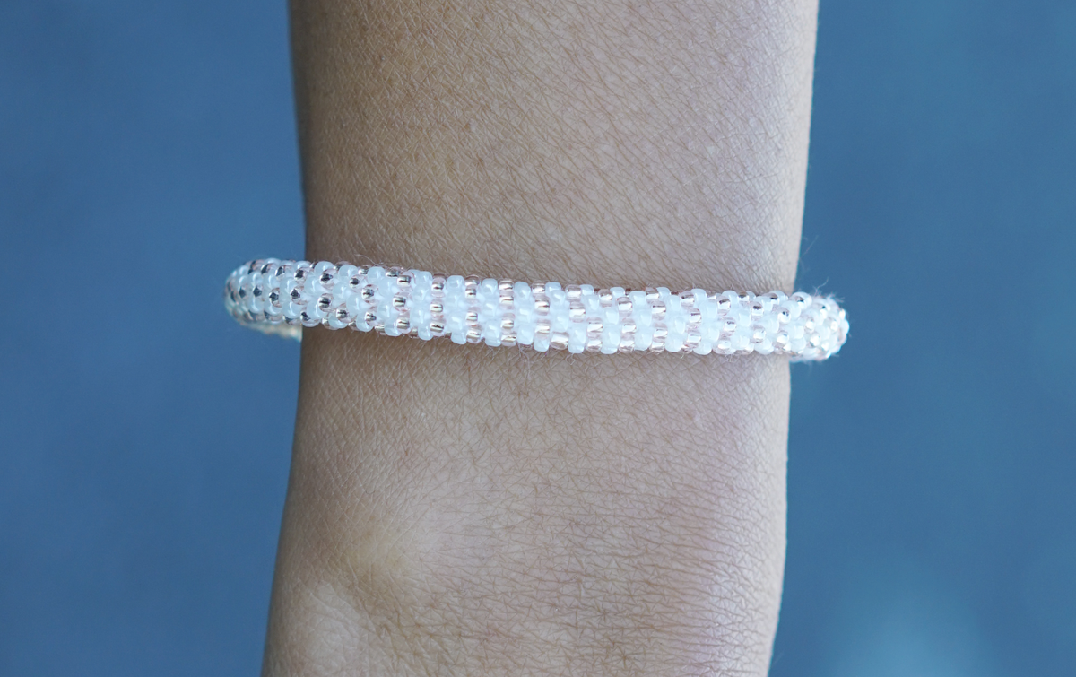 Sashka Co handmade beaded friendship bracelet with white and rose gold glass beads. Crafted in Nepal by skilled artisans in a line pattern.