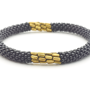 Handmade glass bead black with long gold beads bracelet from Nepal, featuring a roll design. Also known as a beaded bracelet, seed bead bracelet, beach glass bracelet, or sea glass bracelet
