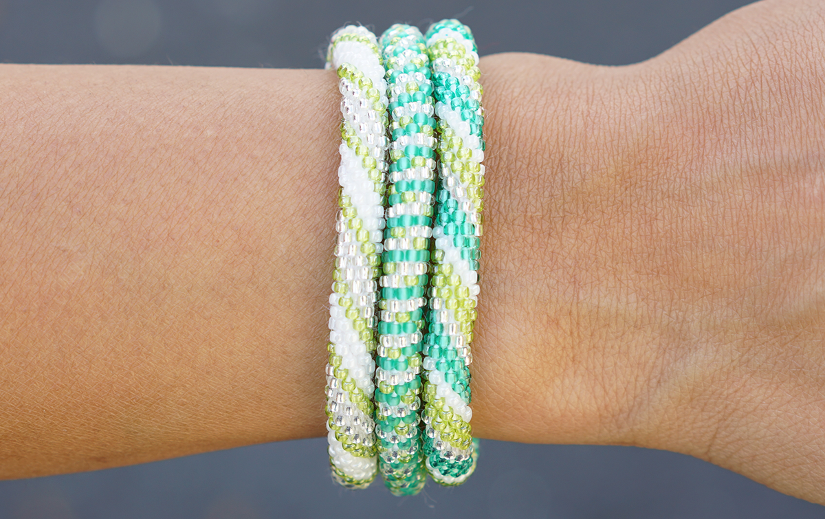 Sashka Co. Bracelet Set 3 Bracelets Green, Light Green, White, Clear. Handmade glass bead bracelet from Nepal, featuring a roll design.
